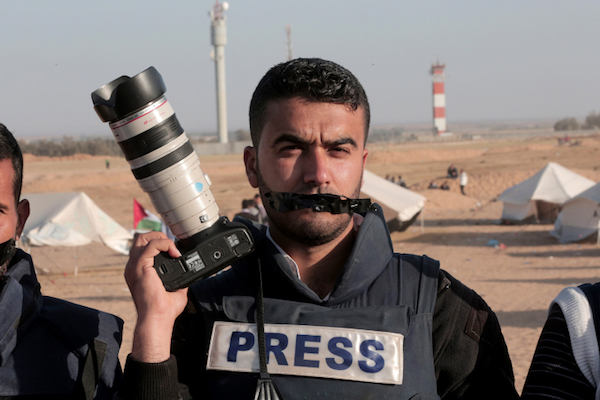 Palestinians protest against the killing of journalist Yaser Murtaja near the fence with Israel, in the southern Gaza Strip, on April 8, 2018. (Abed Rahim Khatib/Flash90)