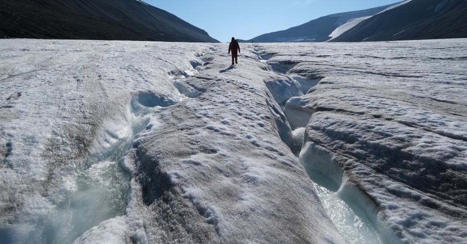 A hiker walks along winding channels carved by water on the surface of the melting Longyearbreen glacier during a summer heatwave on Svalbard archipelago on July 31, 2020 near Longyearbyen, Norway. (Photo: Sean Gallup via Getty Images)