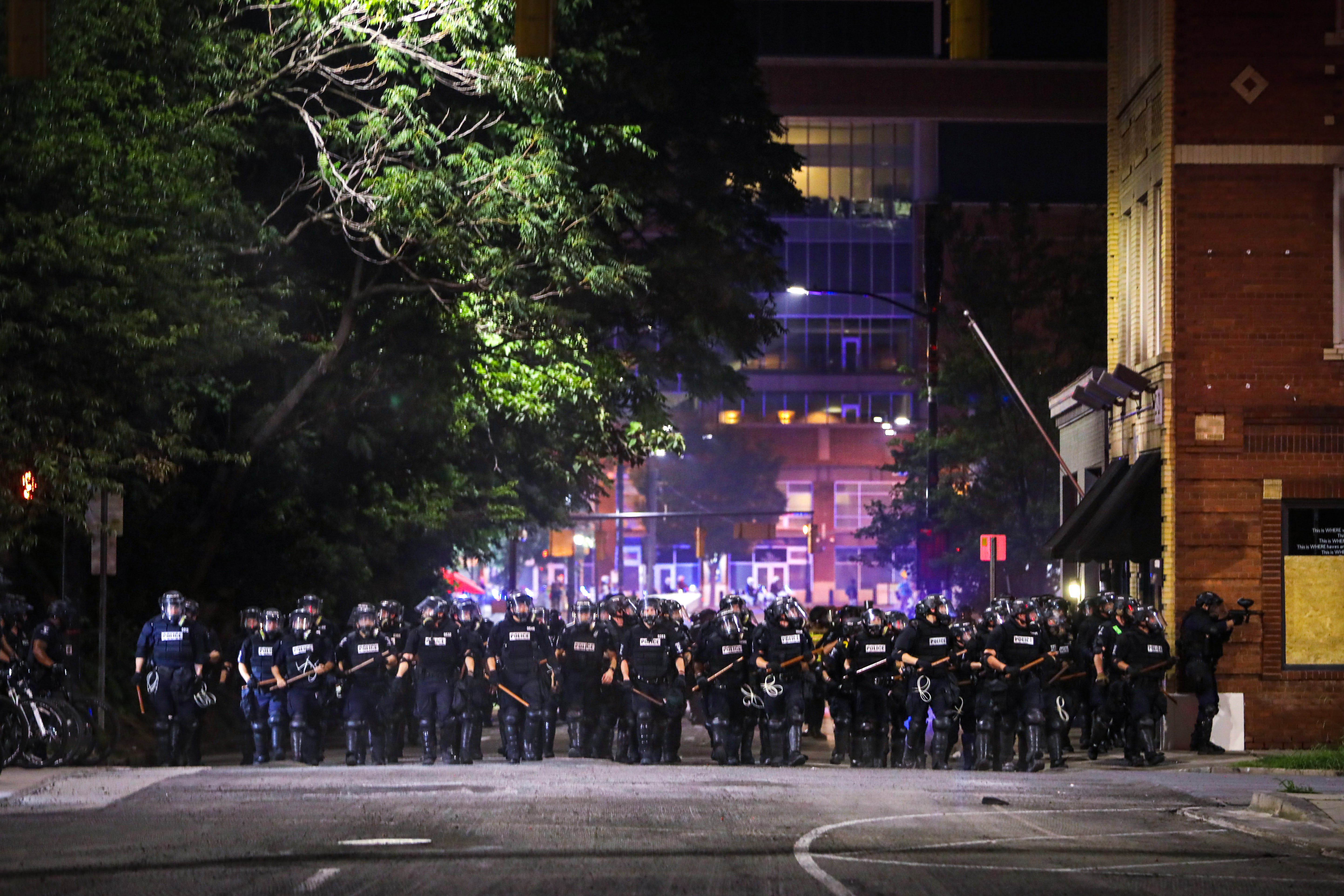 CMPD officers stand in line during a demonstration for the end of police brutaity, with The Spectrum Center behind them near uptown Charlotte, North Carolina on June 2, 2020. - US President Donald Trump said June 2, 2020, that he was now looking for a state to host the Republican National Convention later this summer, after  North Carolina said it could not do so as planned due to the coronavirus pandemic. Charlotte was the designated city to hold the Republican convention from August 24 until August 27. (Photo by Logan Cyrus / AFP) (Photo by LOGAN CYRUS/AFP via Getty Images)