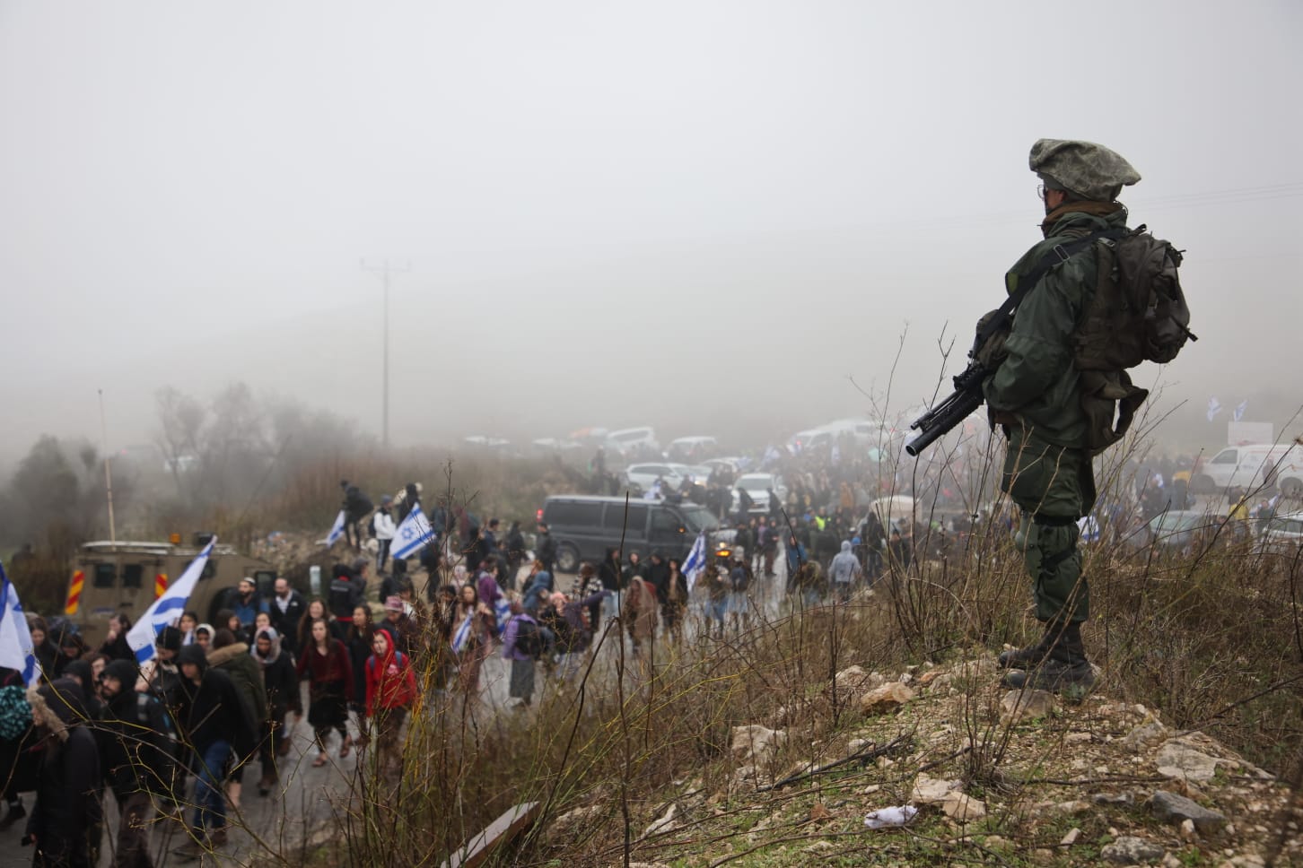 Israeli soldiers guard thousands of settler youth as they march near the outpost of Homesh following the murder of a settler by Palestinians, West Bank, December 23, 2021. (Oren Ziv)