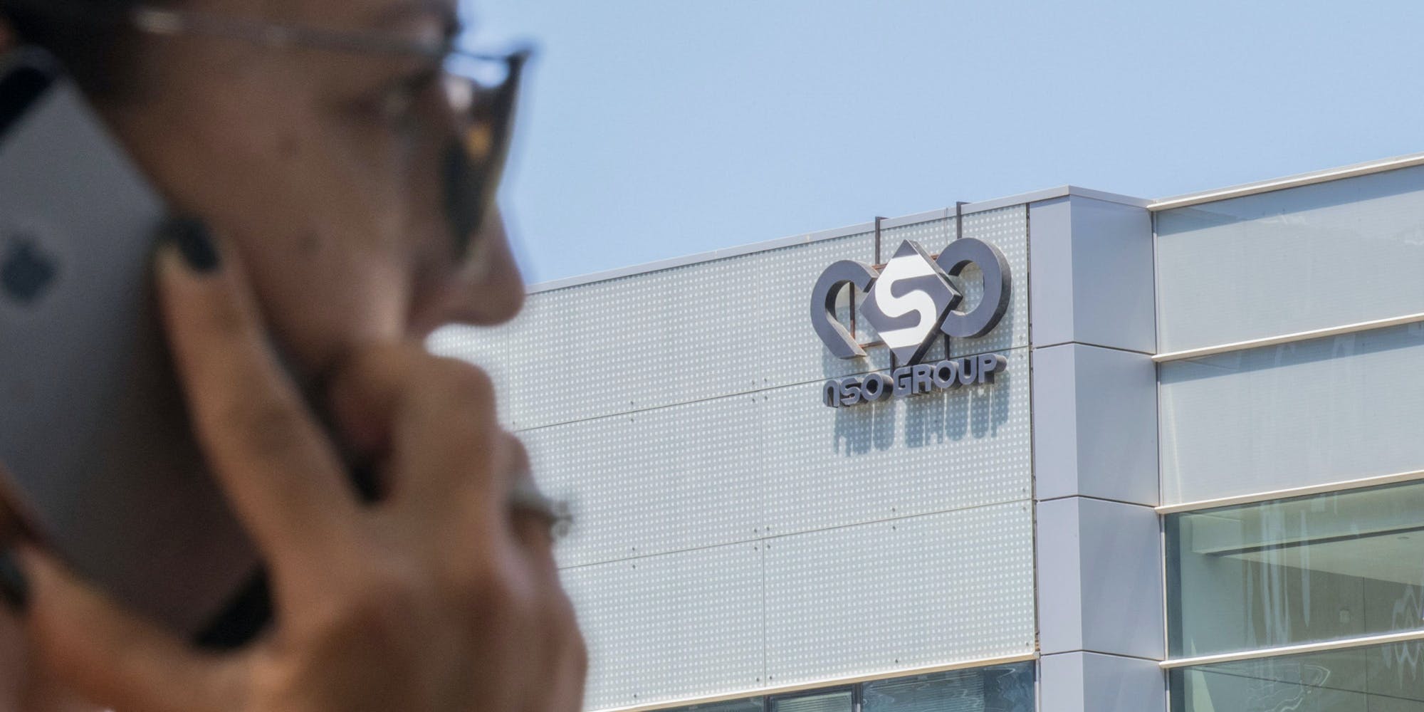 An Israeli woman uses her iPhone in front of the building housing the Israeli NSO group, on August 28, 2016, in Herzliya, near Tel Aviv. - Apple iPhone owners, earlier in the week, were urged to install a quickly released security update after a sophisticated attack on an Emirati dissident exposed vulnerabilities targeted by cyber arms dealers.Lookout and Citizen Lab worked with Apple on an iOS patch to defend against what was called "Trident" because of its triad of attack methods, the researchers said in a joint blog post.Trident is used in spyware referred to as Pegasus, which a Citizen Lab investigation showed was made by an Israel-based organization called NSO Group. (Photo by JACK GUEZ / AFP) (Photo by JACK GUEZ/AFP via Getty Images)
