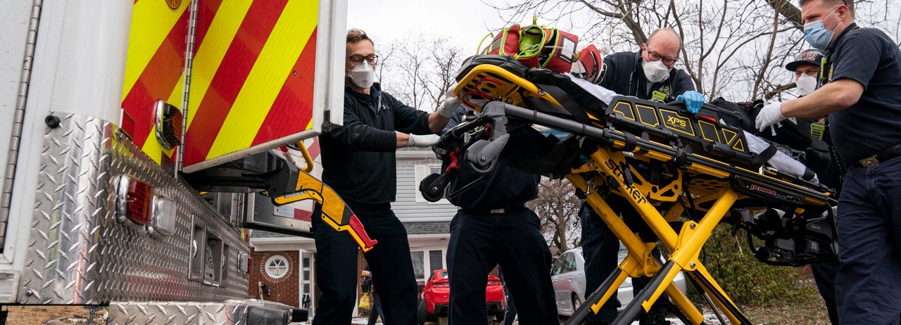 Firefighters and paramedics with Anne Arundel County Fire Department load a pediatric Covid-19 patient who is in cardiac arrest into an ambulance after responding to a 911 emergency call on January 17, 2022, in Glen Burnie, Maryland.