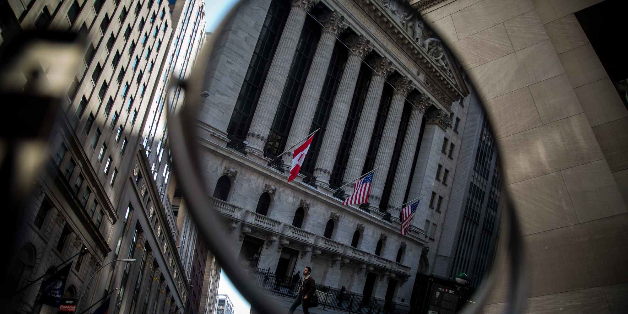 A pedestrian is reflected in a mirror while walking past the New York Stock Exchange (NYSE) in New York, U.S., on Monday, Feb. 22, 2016. U.S. stocks advanced, with the Standard &amp; Poor's 500 Index headed toward a six-week high, amid gains in banks and commodity shares as oil surged. Photographer: Michael Nagle/Bloomberg via Getty Images