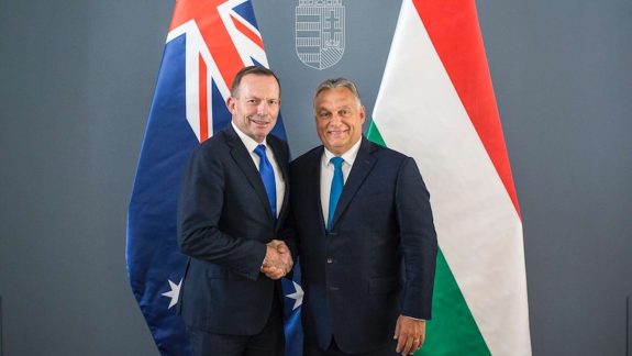 Tony Abbott shakes hands with Viktor Orban in front of Australian and Hungarian flags