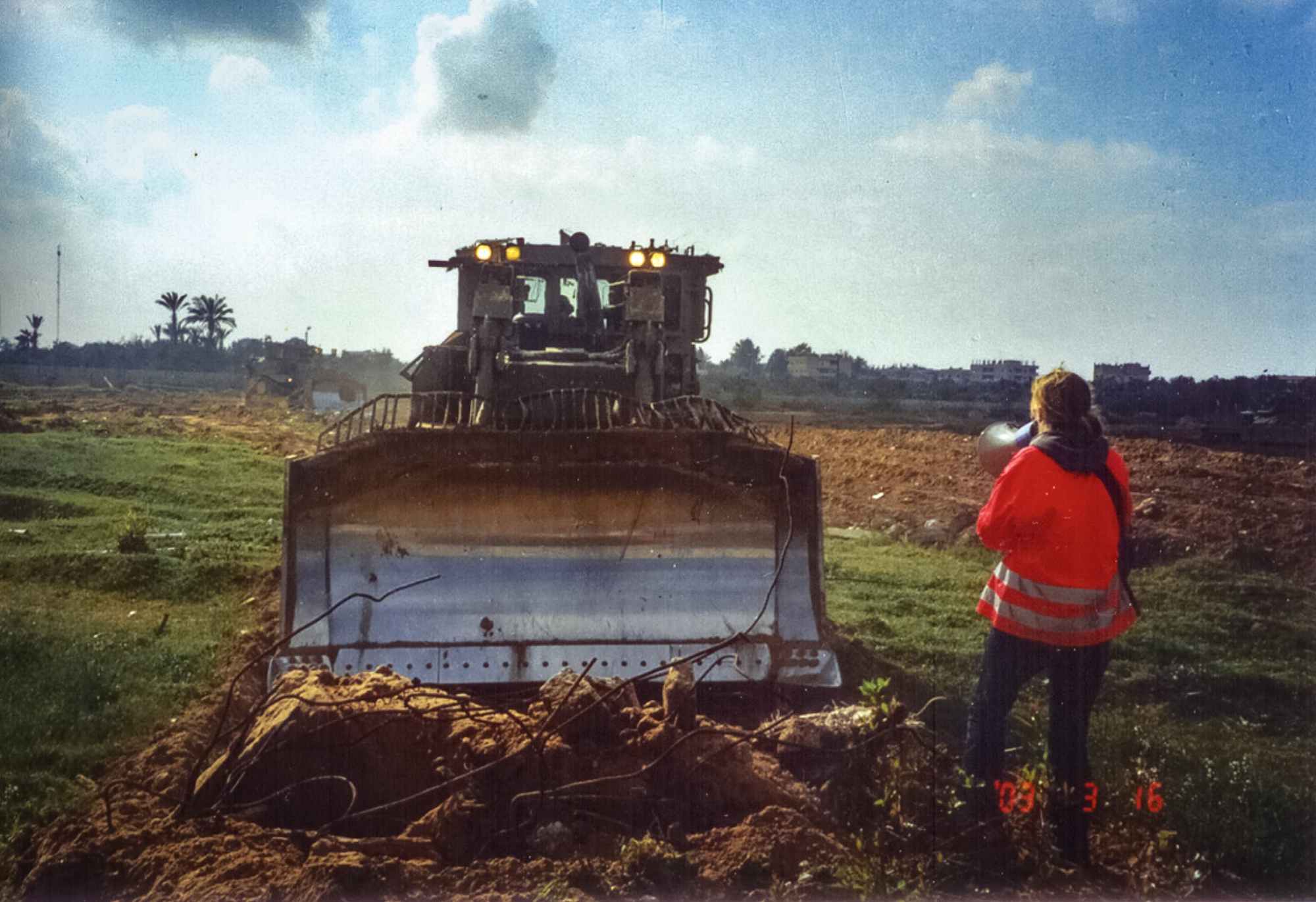 Rachel Corrie stands in front of an Israeli bulldozer to protest the destruction of Palestinian homes along the Rafah-Egypt border on March 16, 2003. Corrie was killed later the same day.
