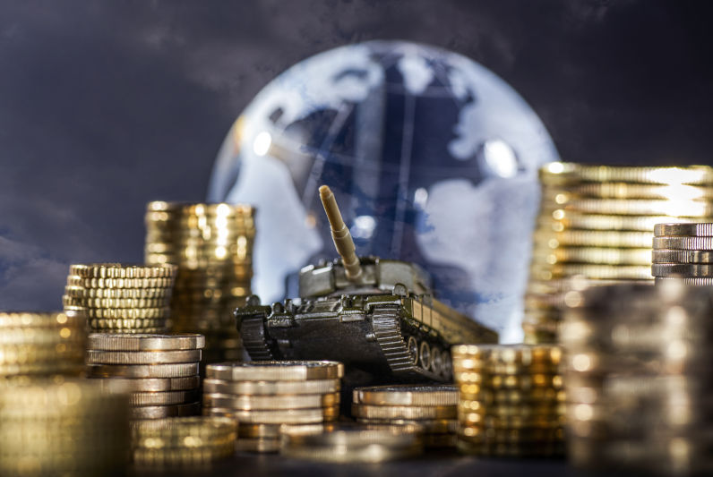 Stacks of money and a tank in front of a globe