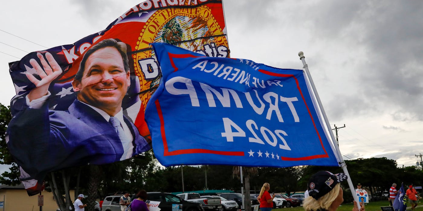 Flags in support of Ron DeSantis, governor of Florida, and Former US President Donald J. Trump ahead of the Florida US senate candidates debate in Lake Worth, Florida, US, on Tuesday, Oct. 18, 2022. With three weeks until Election Day, Republican Senator Marco Rubio and Democrat Representative Val Demings will debate for the first and only time on Tuesday. Photographer: Eva Marie Uzcategui/Bloomberg