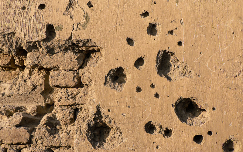 A wall pockmarked by shrapnel, a sad testimony to years of conflict.