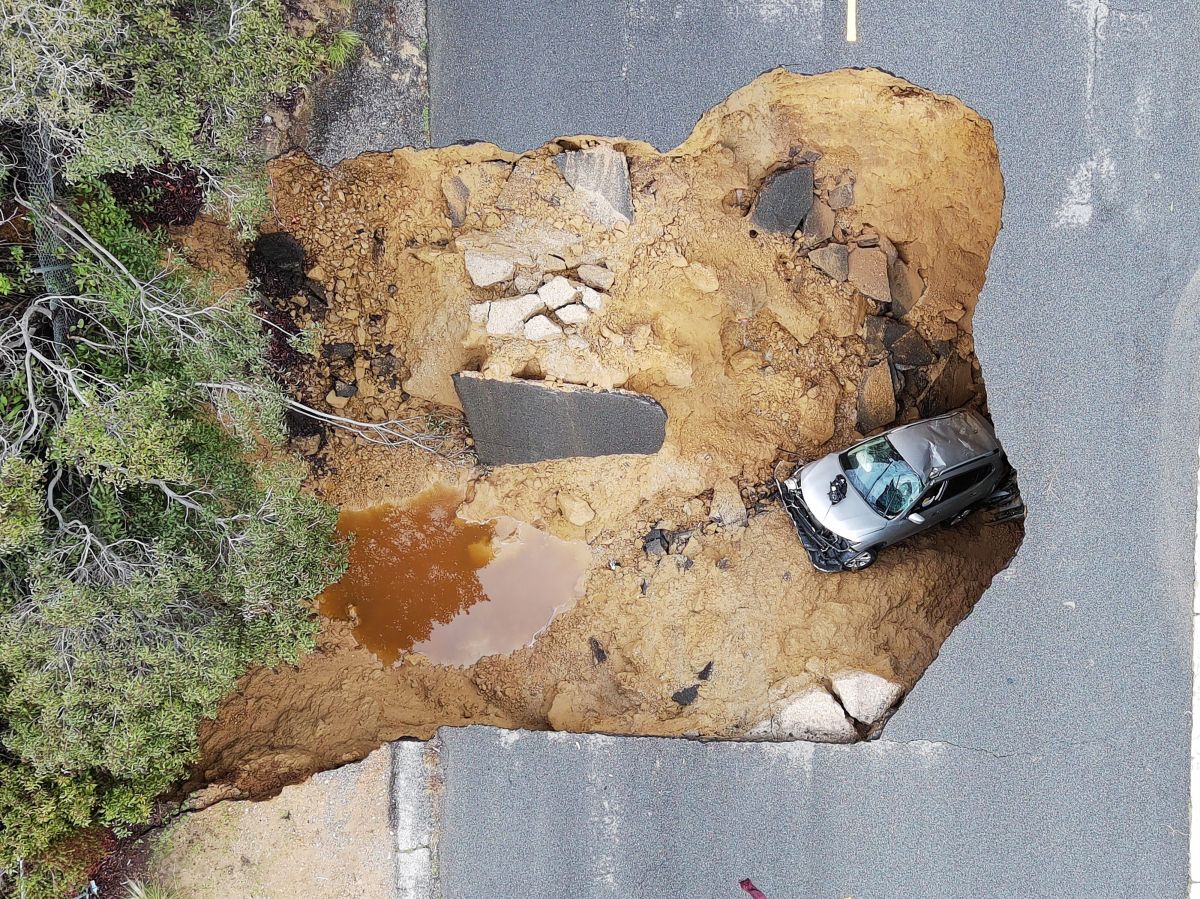 This aerial view shows cars that fell into a large sinkhole