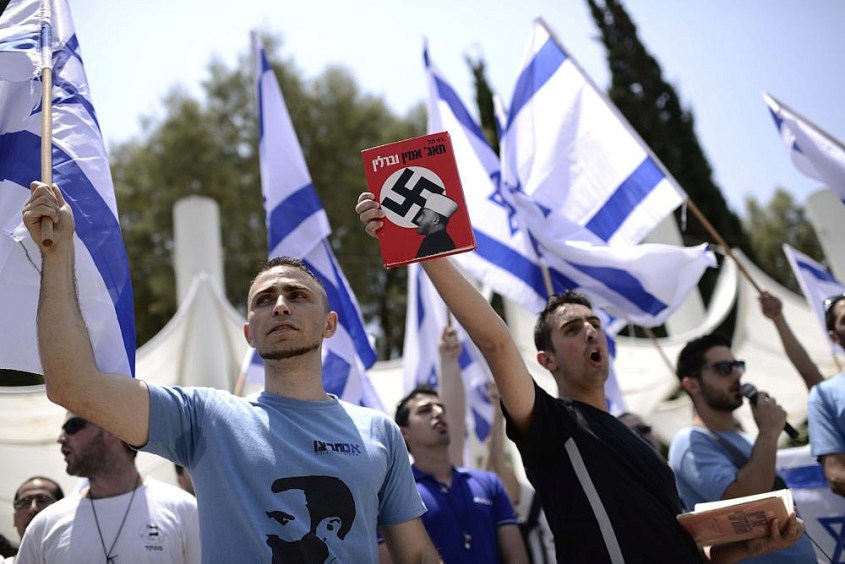 Far-right Israeli activists from the Im Tirzu movement at Tel Aviv University hold book showing Palestinian leader Amin al-Husseini with a swastika, during a protest against the annual Nakba ceremony, May 11, 2014. (Tomer Neuberg/Flash90) Far-right Israeli activists from the Im Tirzu movement at Tel Aviv University hold book showing Palestinian leader Amin al-Husseini with a swastika, during a protest against the annual Nakba ceremony, May 11, 2014. (Tomer Neuberg/Flash90)