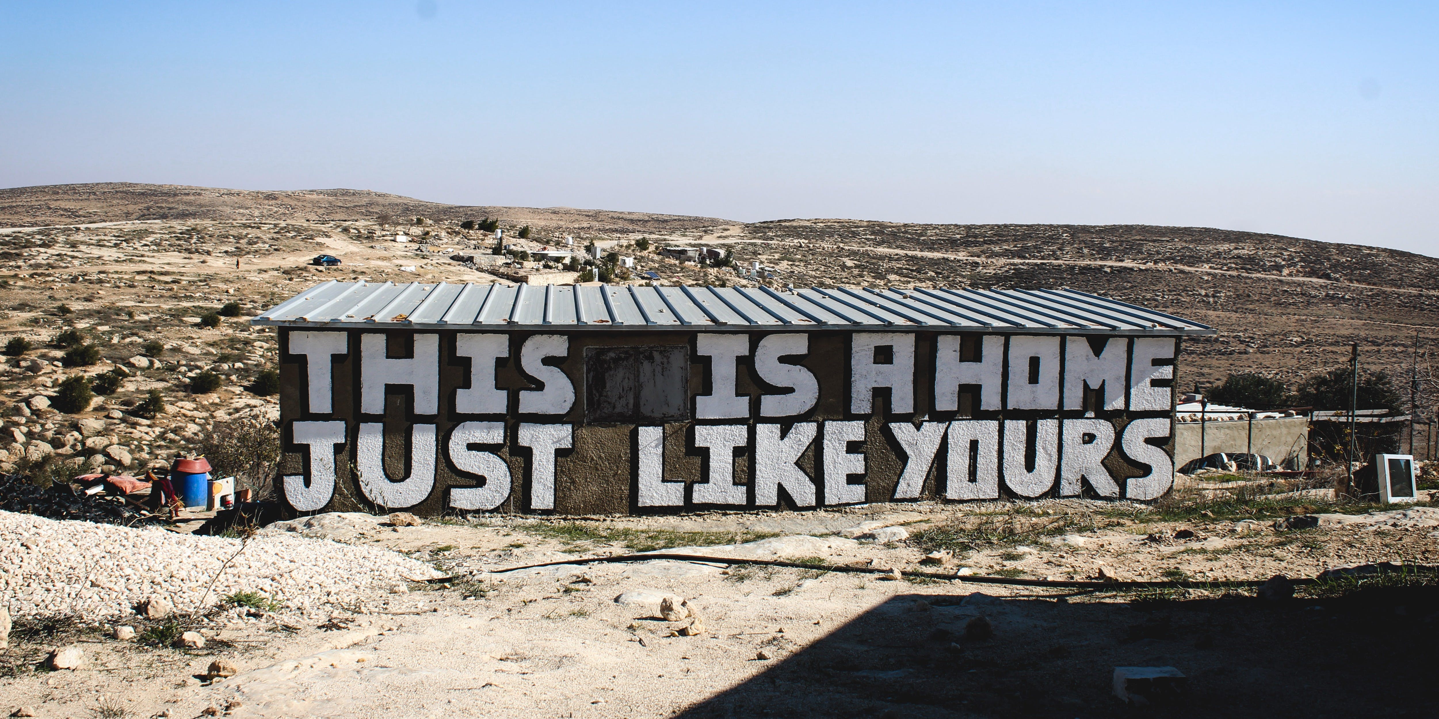 A mural reads, “This is a home just like yours” in Khalet a-Daba’, a Palestinian village inside the Masafer Yatta firing zone, in the occupied West Bank on Jan. 17, 2023.