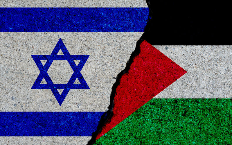 Israel and Palestine flags painted over cracked concrete wall.