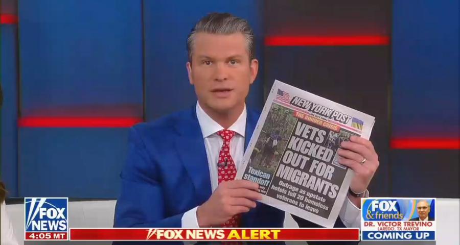Fox & Friends Weekend co-host Pete Hegseth holding up the front page of the fake New York Post story claiming homeless veterans were displaced from hotels for migrants