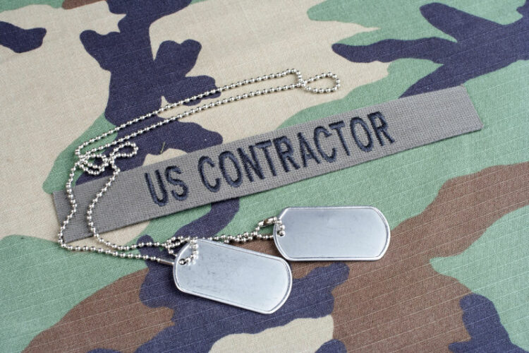 US CONTRACTOR branch tape and dog tags on woodland camouflage uniform.