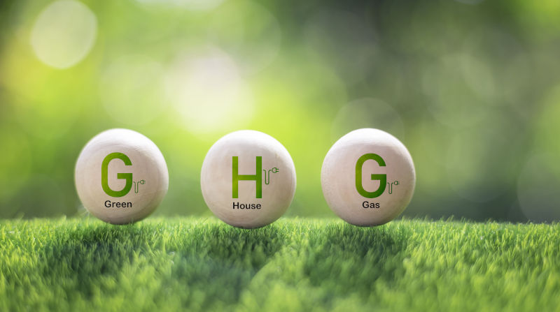 (Greenhouse Gases) The abbreviation GHG on a wooden block symbolises the change in greenhouse gases.