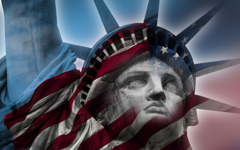 Double exposure image of the Statue of Liberty and the American flag.