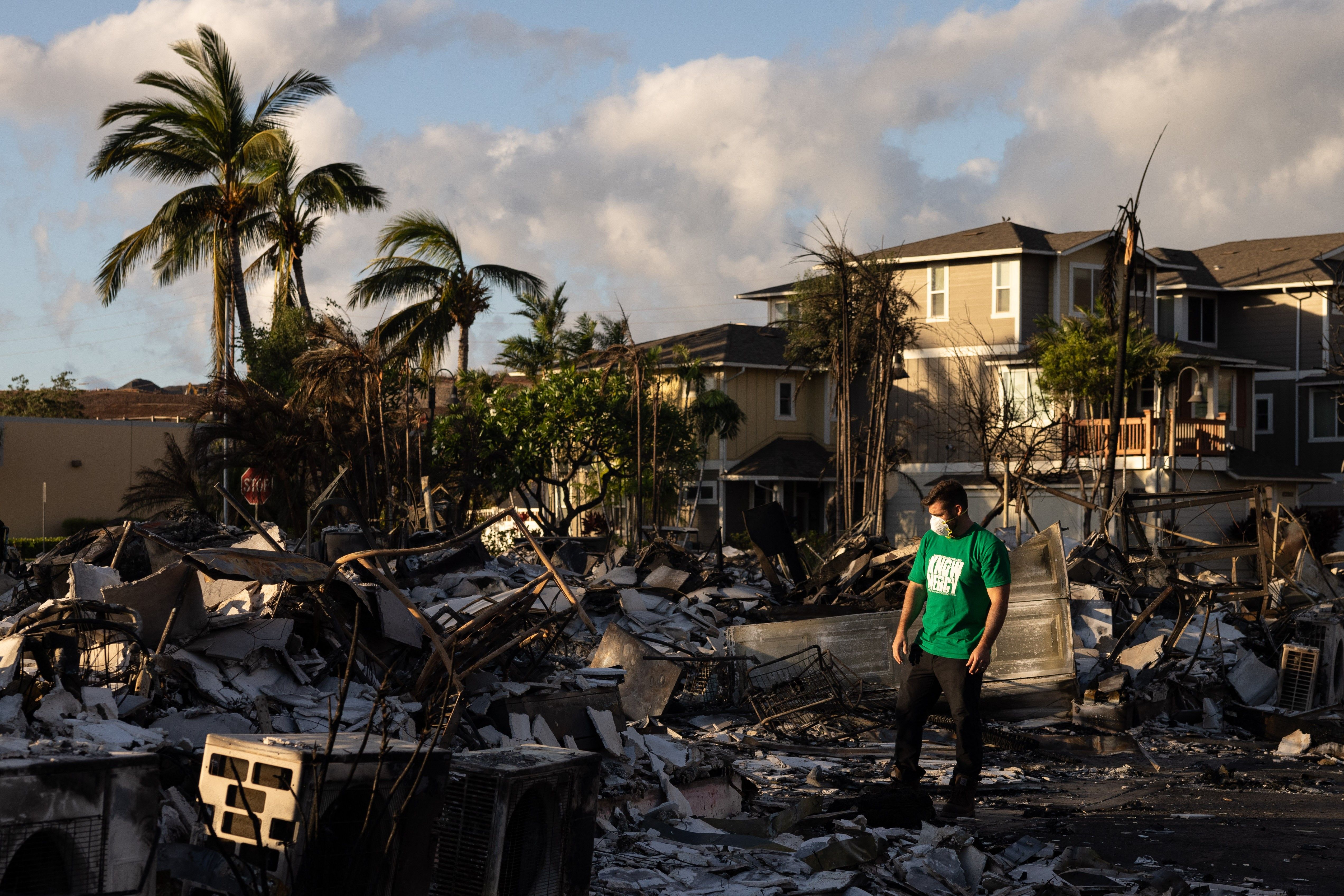 A volunteer makes a damage assessment of a charred apartment complex