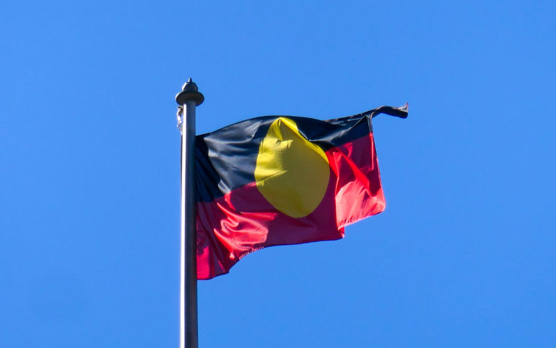 The Australian Aboriginal flag flies in the wind on the Queen Victoria Building in the central business district of Sydney. This image was taken on a sunny winter morning on 19 June 2023.