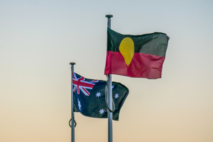 The Australian and Australian Aboriginal flags fly at Bondi Icebergs Club, Bondi Beach, Sydney. This image was taken from the coastal walkway at sunset on a cold, sunny winter day on 17 June 2023.