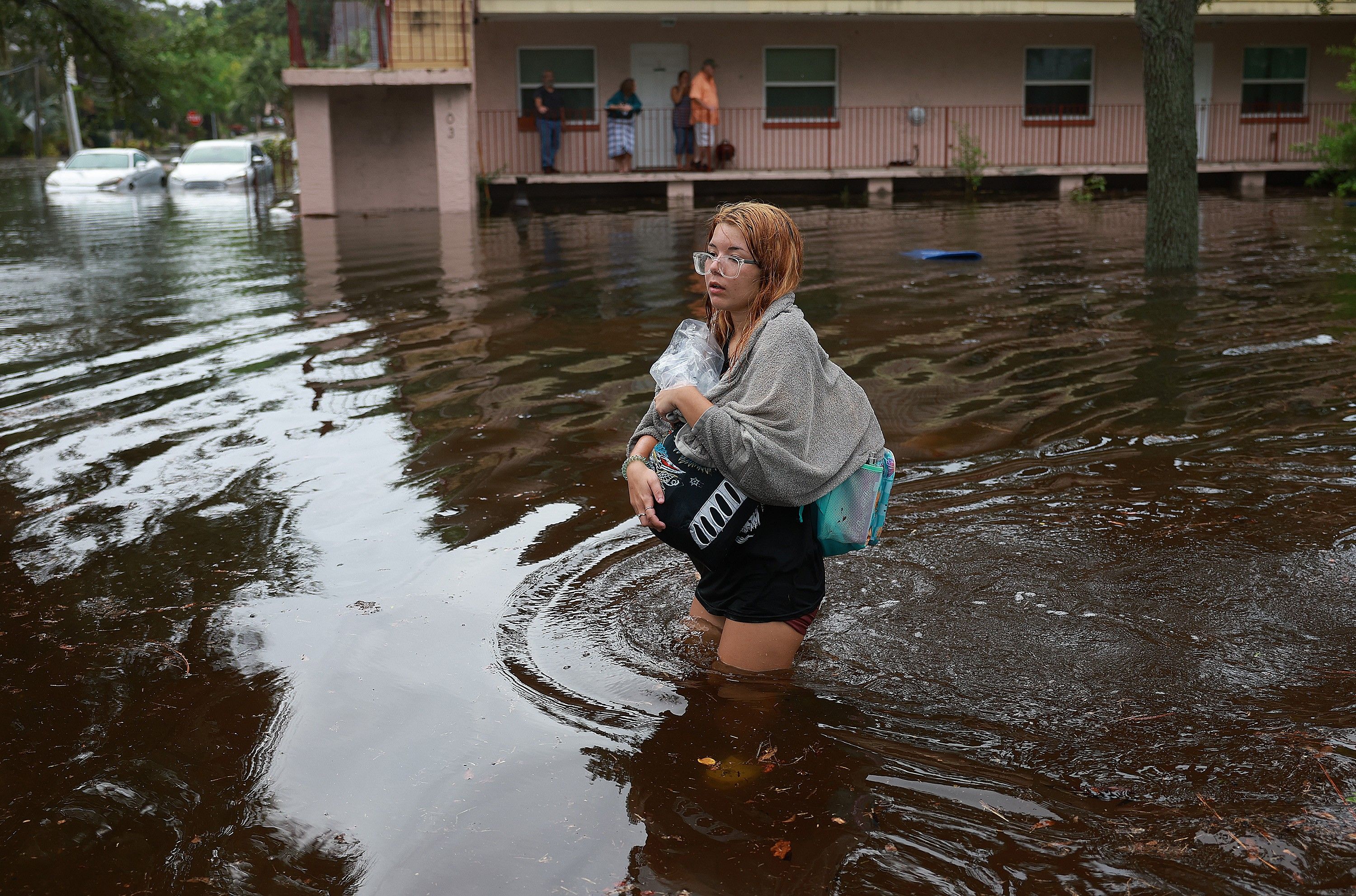 woman wades through flood waters from Hurricane Idalia 