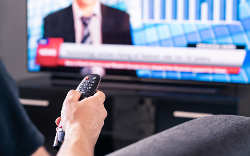 Breaking news on tv. Man watching live television broadcast program.