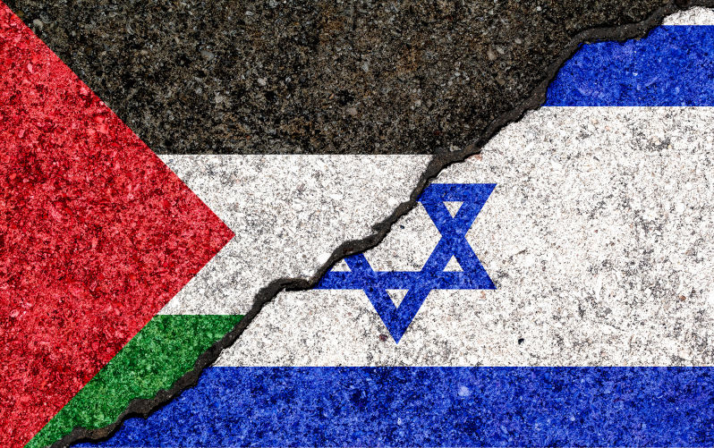 Flags of Israel and Palestine painted on cracked wall.