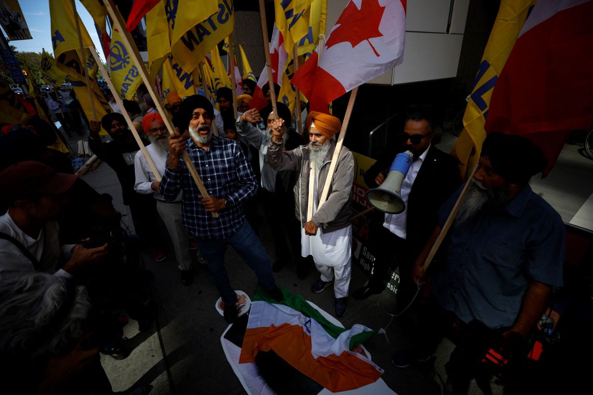People stomp on an Indian flag and a cutout of Indian prime minister Narendra Modi during a Sikh rally outside the Indian consulate in Toronto to raise awareness for the Indian government's alleged involvement in the killing of Sikh separatist Hardeep Singh Nijjar in British Columbia on September 25, 2023. Prime Minister Justin Trudeau's assertion on September 17, 2023 that agents linked to New Delhi may have been responsible for the June 18 murder of Hardeep Singh Nijjar, a Canadian citizen, sent shockwaves through both countries, prompting the reciprocal expulsion of diplomats. (Photo by Cole BURSTON / AFP) (Photo by COLE BURSTON/AFP via Getty Images)