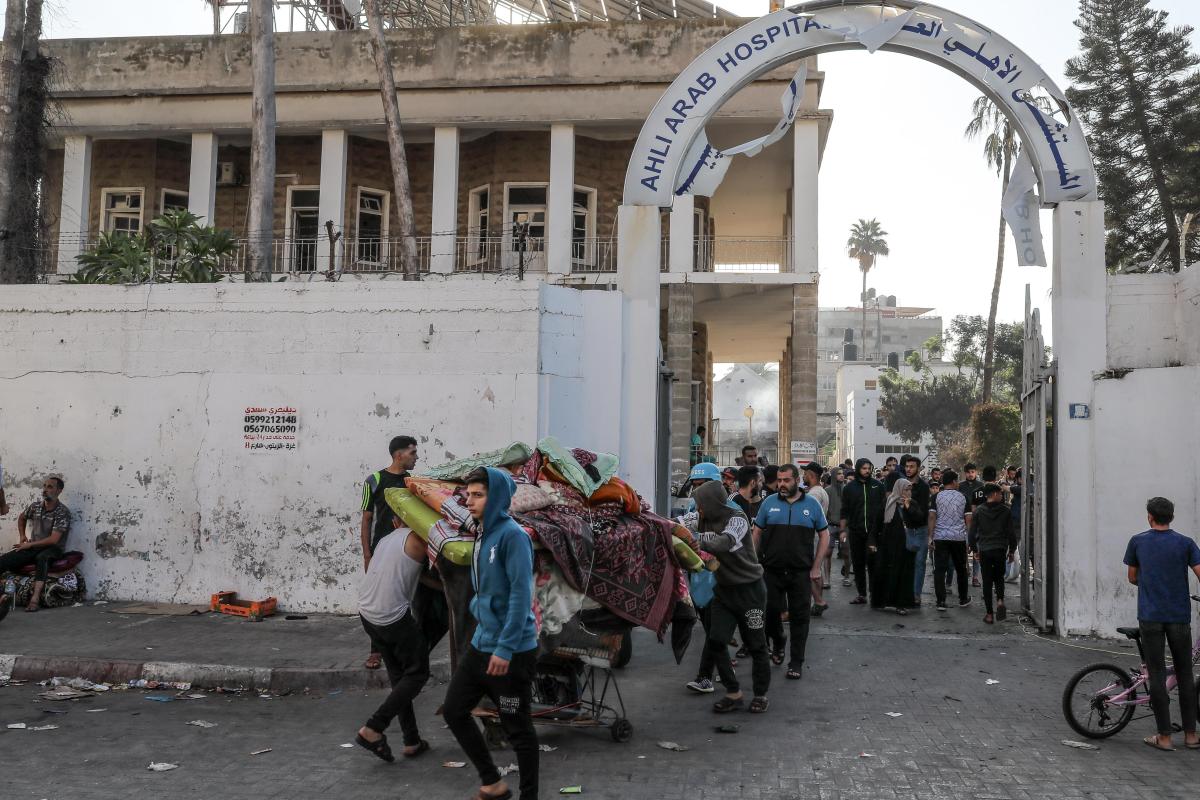 GAZA CITY, GAZA - OCTOBER 18: Palestinians carry usable items from the heavily damaged Al-Ahli Baptist Hospital building after bombing in Gaza City, Gaza on October 18, 2023. According to the Palestinian authorities, Israeli army is responsible for the deadly bombing. While the number of deaths as a result of the attack on the hospital increased to 471, major damage occurred in the hospital building and its surroundings. (Photo by Belal Khaled/Anadolu via Getty Images)