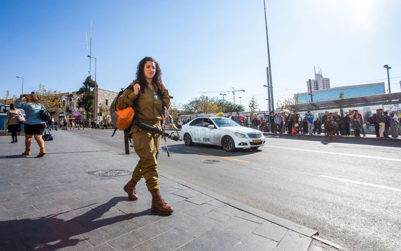 12-26-2014 Jeruisalem , Israel. Girl soldier on a short weekend leave with a Tar-21 assault rifle on street of Jerusalem.