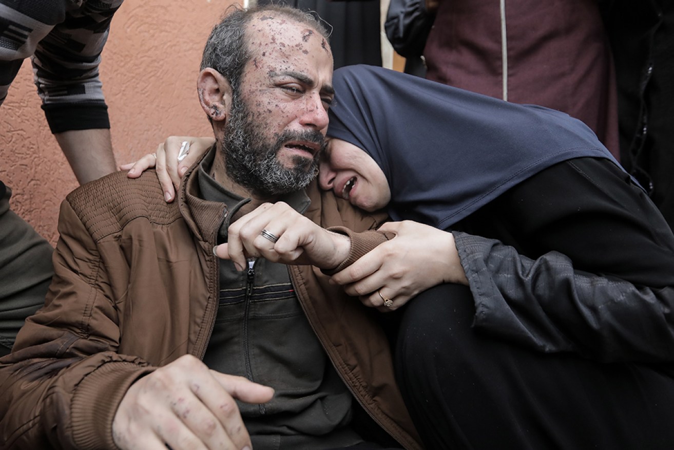 People mourn as they collect the bodies of Palestinians killed in airstrikes on Sunday at Khan Yunis, Gaza.