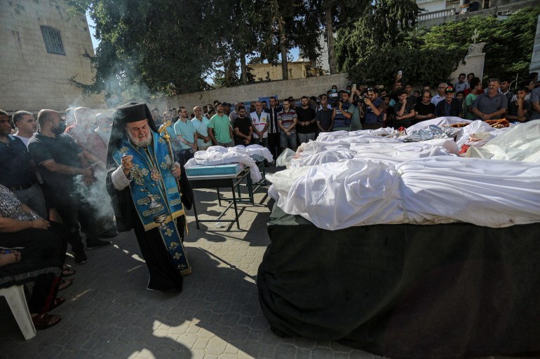 Archbishop Alexios of Tiberias visits Saint Porphyrius Orthodox church in Gaza City, which was severely damaged in an Israeli airstrike on Thursday. At least 18 people were killed [Abdelhakim Abu Riash/Al Jazeera]