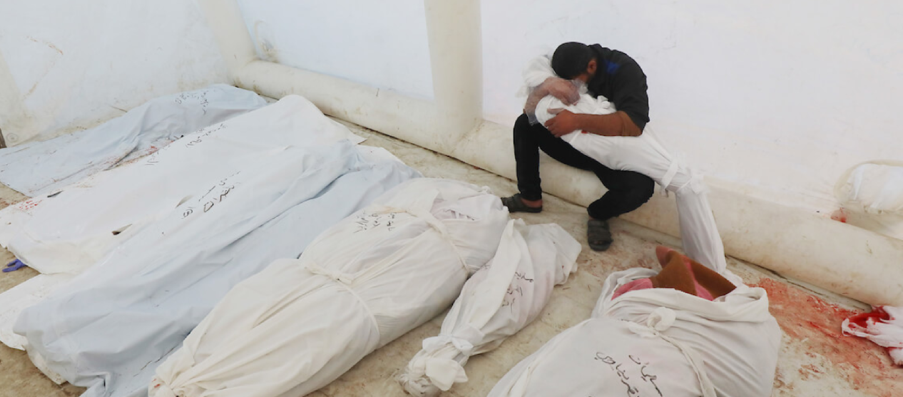 A Palestinian man at Gaza's Al-Aqsa Hospital mourns as he holds the body of a relative killed in Israeli airstrikes 