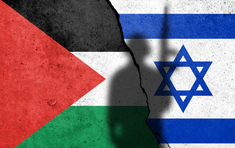 Flags-of Palestine and Israel painted on the concrete wall with soldier shadow. Gaza and Israel conflict.