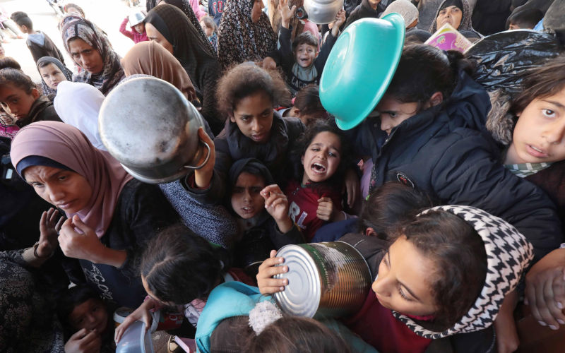 Palestinian people holding empty bowls try to reach out for food distributed by volunteers at donation point as Israeli attacks Palestinian people holding empty bowls try to reach out for food distributed by volunteers at donation point as Israeli attacks continue in Dair El-Balah, Gaza on January 26, 2024. The UN Agency for Palestinian Refugees UNRWA has termed humanitarian conditions in the Gaza Strip.. Photo by Omar Ashtawy apaimages Dair El-Balah Gaza Strip Palestinian Territory 260124_Dair_EL-Balah_OSH_1_0038 Image: alamy/ xapaimagesxOmarxAshtawyxxapaimagesx