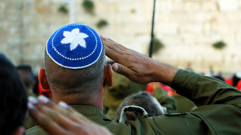 Jerusalem, Israel - May 25, 2017: Israeli soldier military man saluting to the Western wall in Jerusalem. Western wall or Wailing wall or Kotel is the most sacred place for all jewish people.