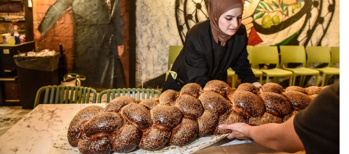 Arabic women set out a giant challah for an inter-faith Shabbat dinne 