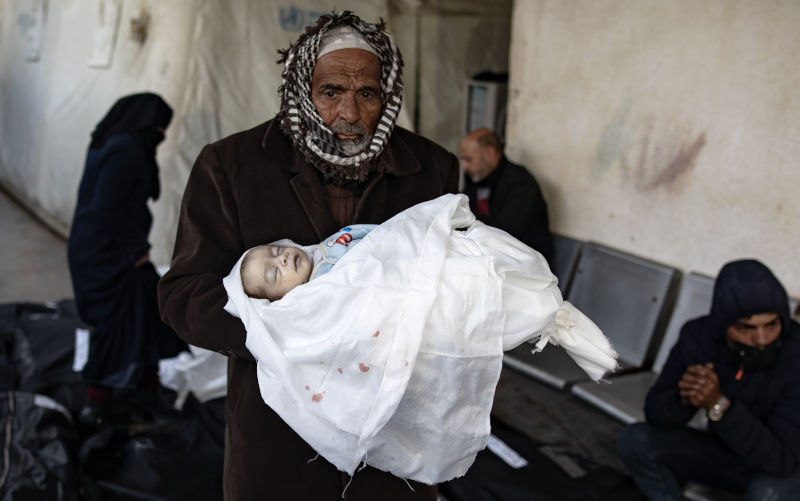 A man holds the body of a baby killed in an Israeli air strike, at Al-Najjar Hospital in Rafah, southern Gaza Strip, 12 February 2024. According to the Palestinian Health Ministry, more than 60 people have been killed and over 230 others have been injured in the airstrikes carried out by the Israeli military. According to a statement released by the Israeli Defense Forces (IDF), two Israeli hostages were rescued during an overnight operation in Rafah. More than 28,300 Palestinians and over 1,300 Israelis have been killed, according to the Palestinian Health Ministry and the Israel Defense Forces (IDF), since Hamas militants launched an attack against Israel from the Gaza Strip on 07 October 2023, and the Israeli operations in Gaza and the West Bank which followed it. Image: Alamy/ EPA/HAITHAM IMAD ATTENTION EDITORS: GRAPHIC CONTENT