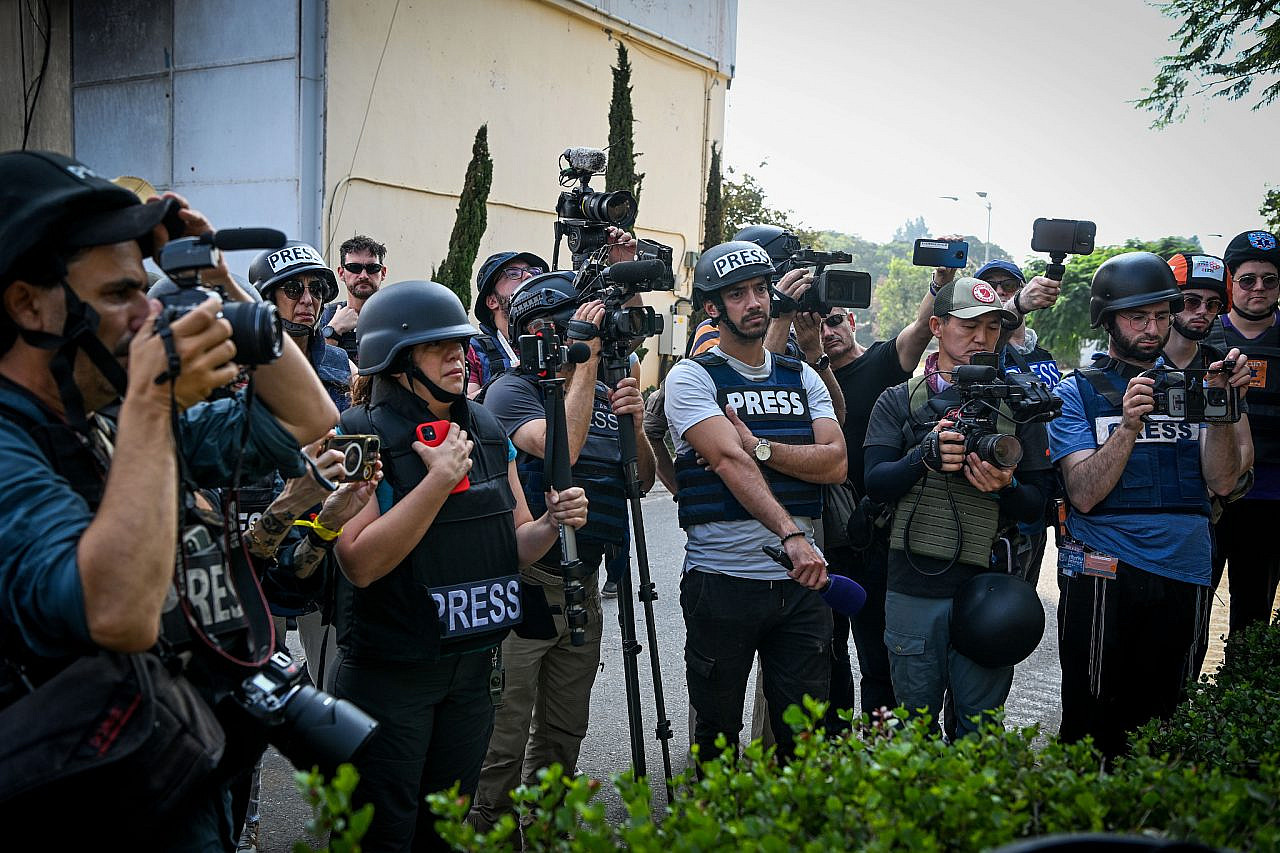 Journalists seen around the destruction caused by the Hamas-led October 7 attacks in Kibbutz Kfar Aza, southern Israel, November 2, 2023. (Arie Leib Abrams/Flash90)