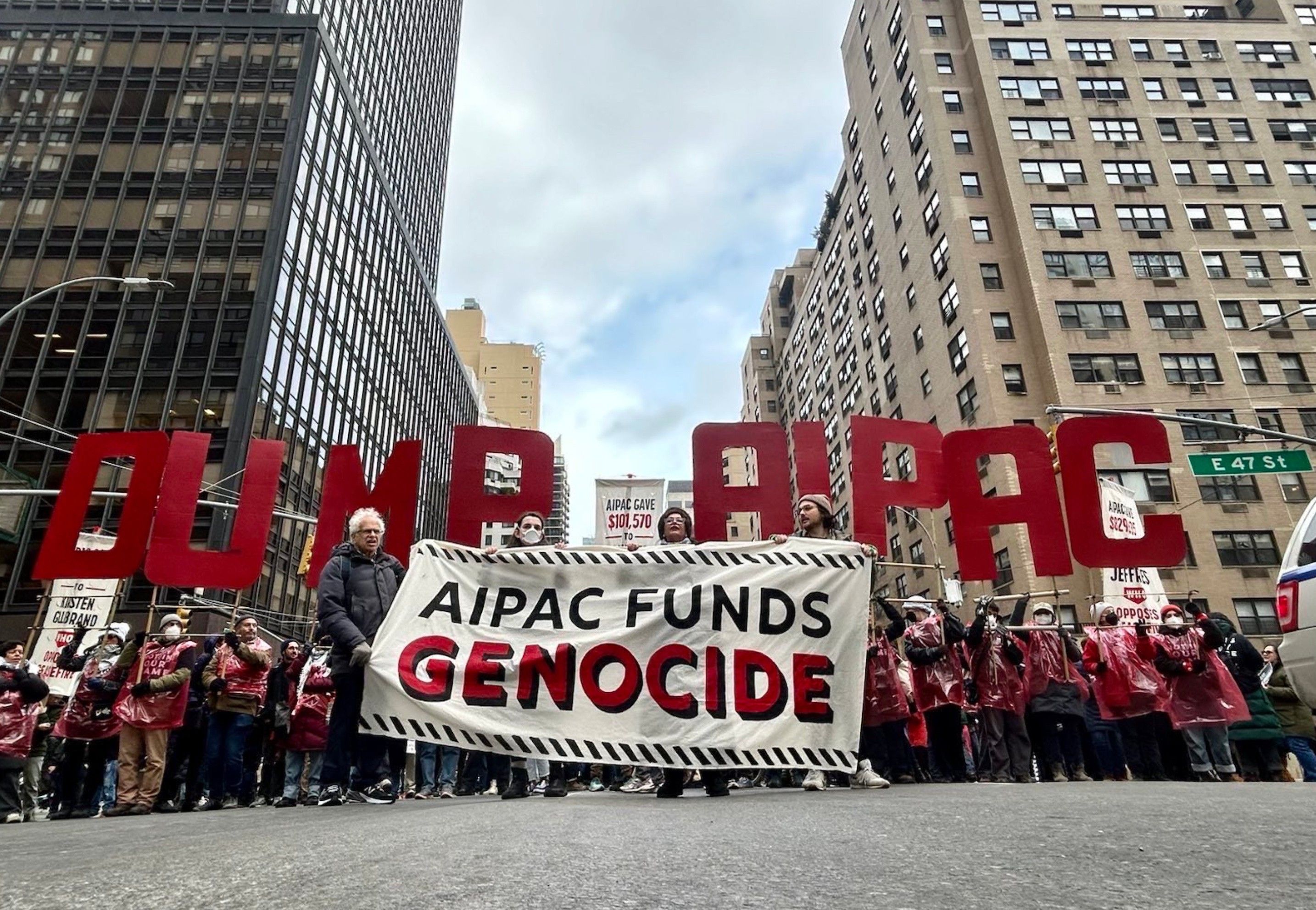 Jewish protesters in NYC hold a banner reading, "AIPAC funds genocide" 