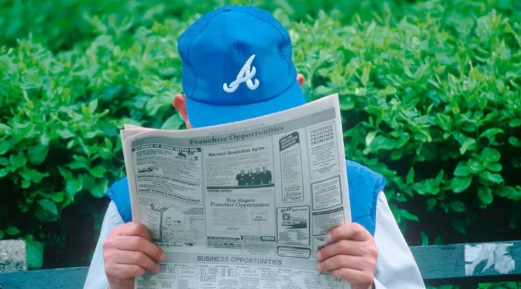 Man with hat reading newspaper