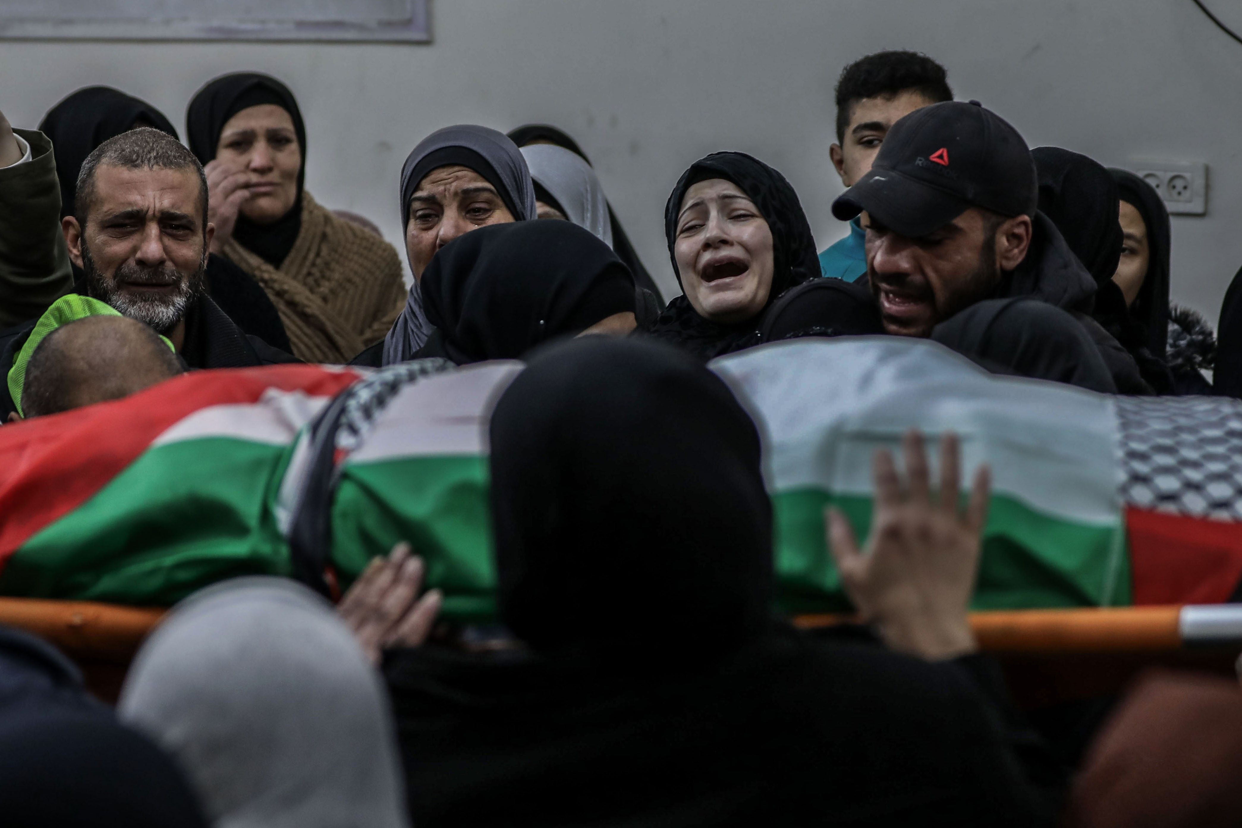 Relatives mourn over the body of Palestinian Yazan Al-Najmi 