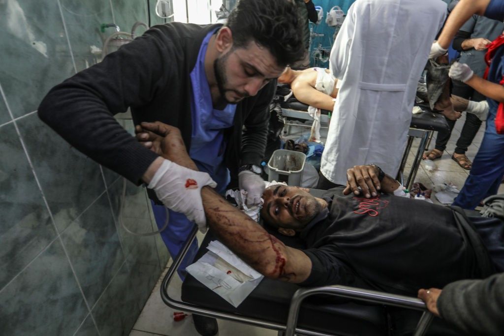 A Palestinian medic treats a man injured in an Israeli attack