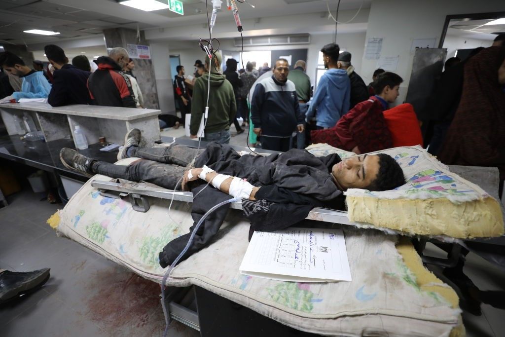 A young Palestinian manwounded in Israel's Flour Massacre lies in a hospital