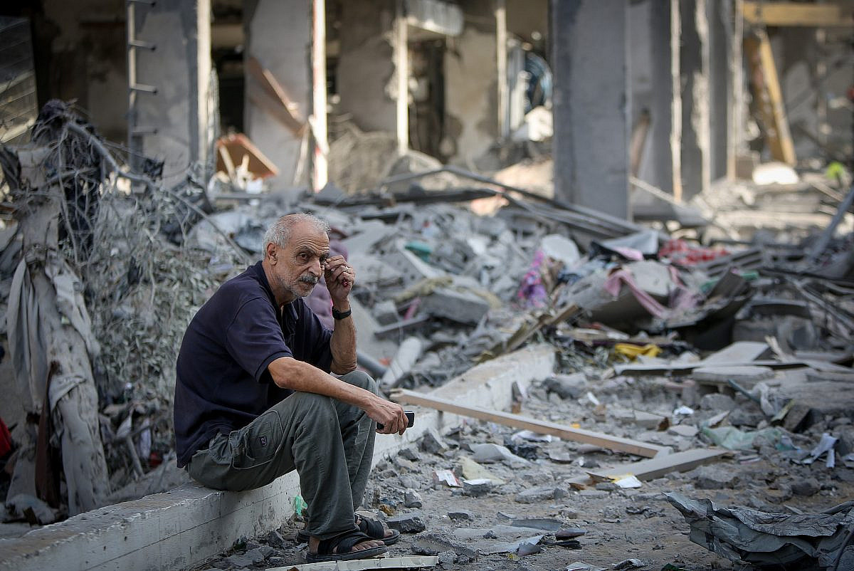 Palestinians walk through rubble of houses destroyed by Israeli airstrikes in the Jabalia area, northern Gaza Strip, October 11, 2023. (Atia Mohammed/Flash90)
