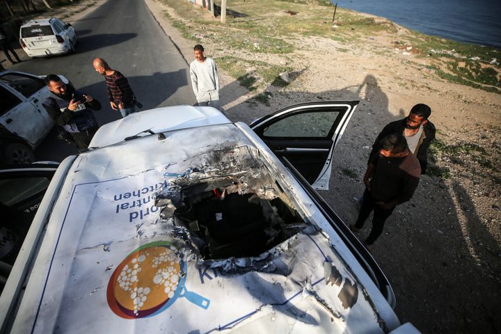Palestinians are standing next to a vehicle in Deir Al-Balah, in the central Gaza Strip, on April 2, 2024, where employees from the World Central Kitchen, including foreigners, were killed in an Israeli airstrike, according to the NGO. (Photo by Majdi Fathi/NurPhoto via Getty Images)