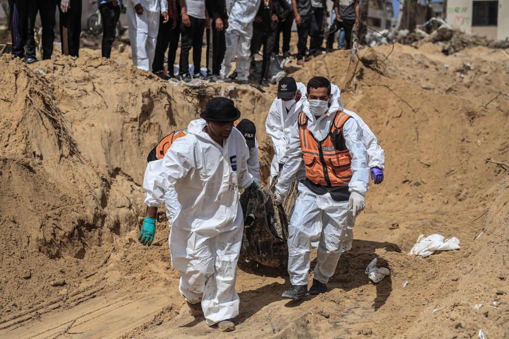 Civil Defense Authority teams remove bodies of Palestinians