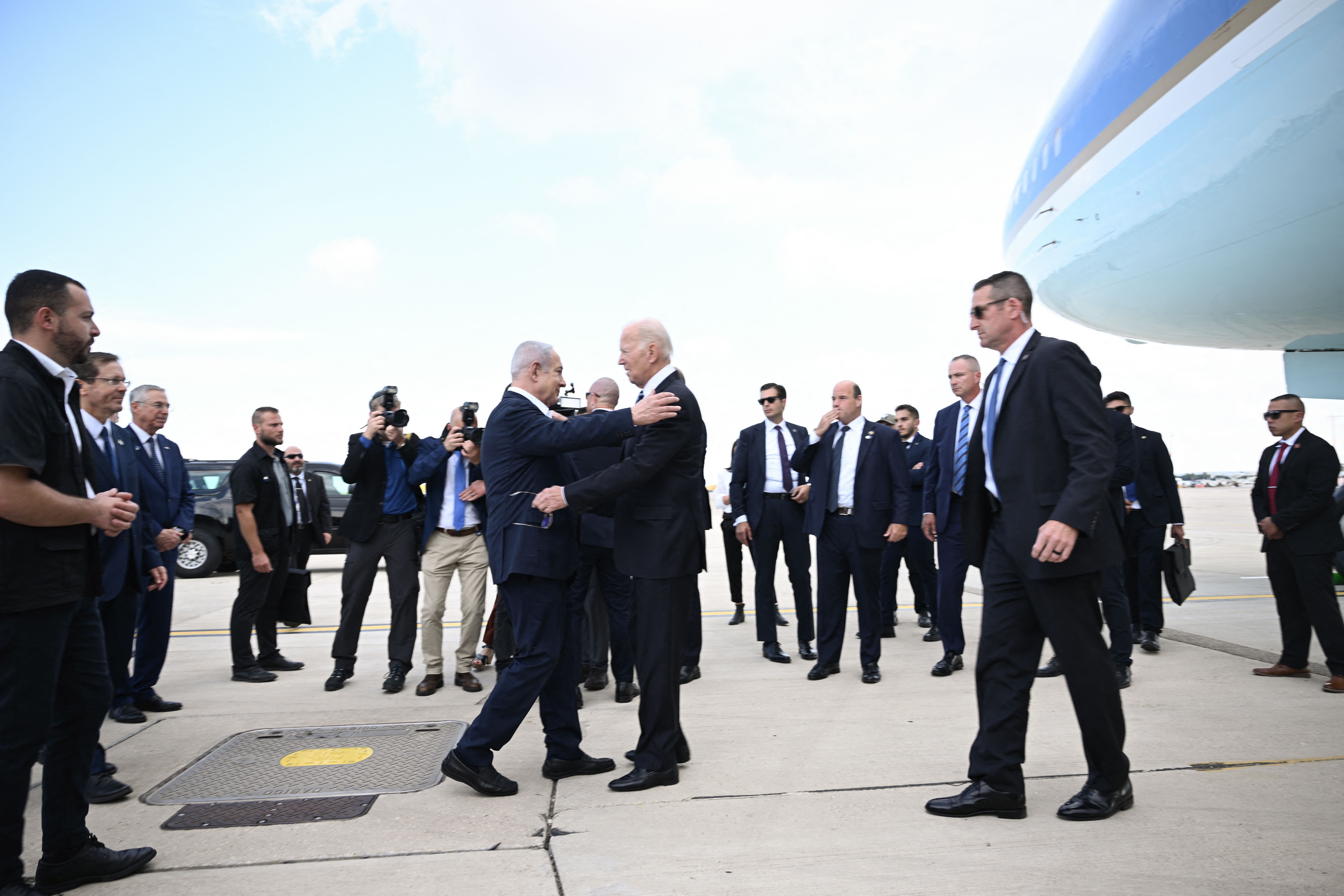 Israel Prime Minister Benjamin Netanyahu (L) greets US President Joe Biden upon his arrival at Tel Aviv's Ben Gurion airport on October 18, 2023, amid the ongoing battles between Israel and the Palestinian group Hamas. Biden landed in Israel on October 18, on a solidarity visit following Hamas attacks that have led to major Israeli reprisals. (Photo by Brendan SMIALOWSKI / AFP) (Photo by BRENDAN SMIALOWSKI/AFP via Getty Images)