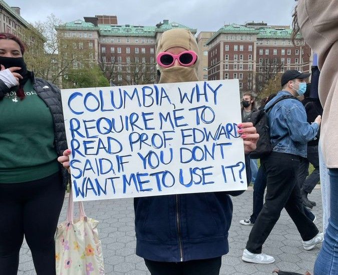 Student at Columbia holding sign reading, "Columbia, why require me to read Prof. Edward Said, if You don't want me to use it?"