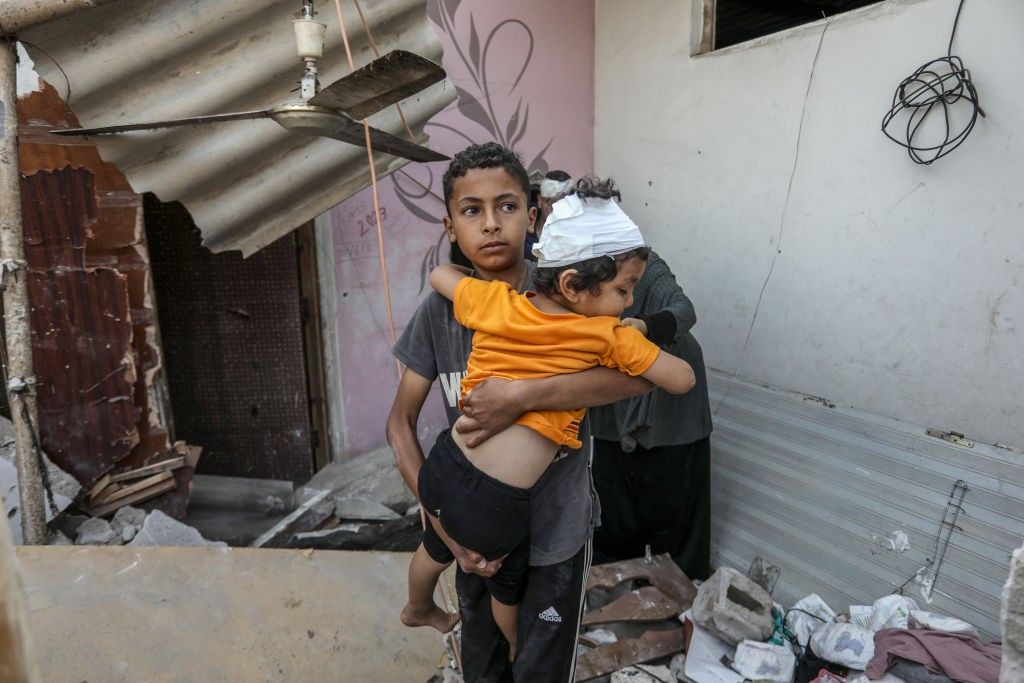Palestinians, including children, collect remaining belongings