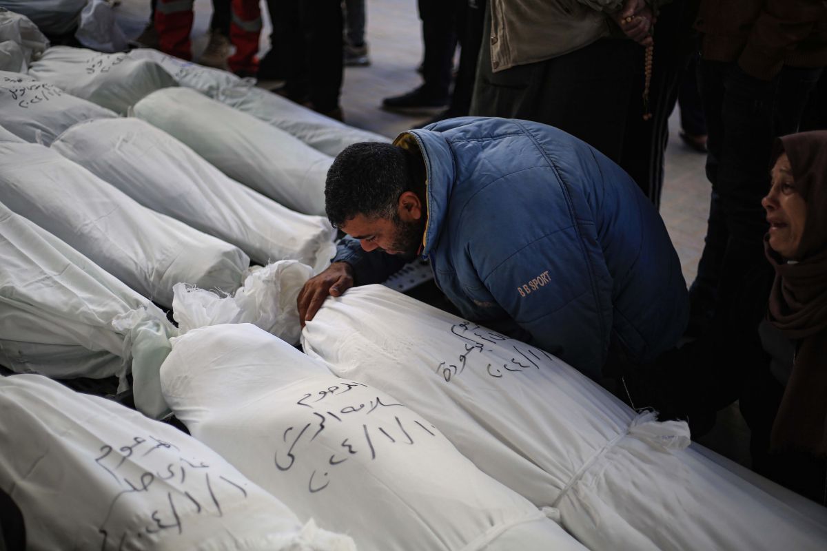 Palestinians mourn next to the bodies of their relatives 